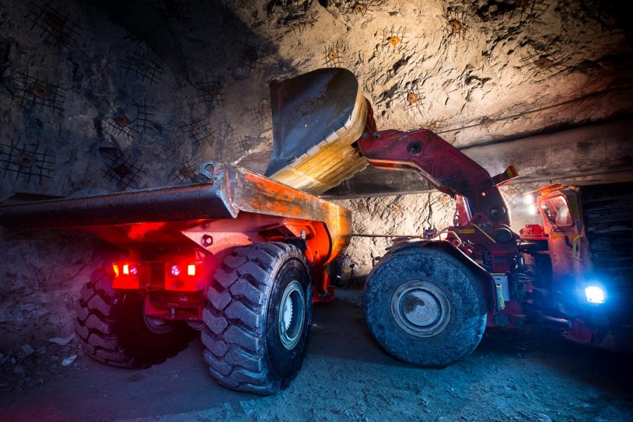 Gold mining underground. Loading truck with golden ore in the tunnel ...